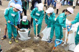 土のう袋作りを体験する小学生