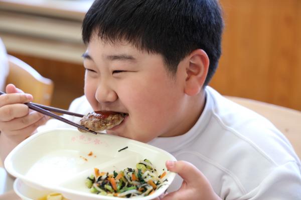 ジビエハンバーグをほおばる児童